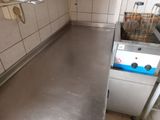 stainless steel counter top in a commercial kitchen with a sink and dishwasher