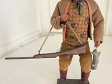figurine of a man holding a gun and a rifle
