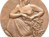 an image of a bronze medal depicting a woman with a basket of grapes