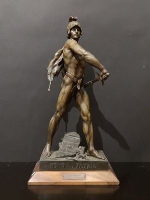 a bronze statue of a man holding a sword on a wooden base