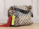 louis vuittou bag with tassels on wooden table