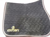 black and white quilted saddle pad with kentucky logo on it