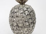 a silver pineapple shaped object on a white surface