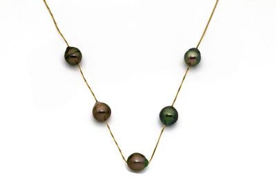 un gros plan d'un collier orné de perles noires sur fond blanc