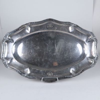 une assiette ancienne en argent, ornée d'un motif décoratif sur le bord