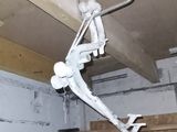 a picture of a man hanging from a ceiling in a garage