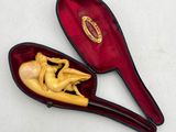 a wooden spoon with a figurine in it in a red case