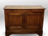 une vieille armoire en bois à deux portes, avec un tiroir sur le dessus