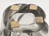 a silver vase with gold squares on top of it