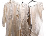 three white shirts hanging on a clothes rack on a white background
