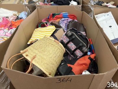 une boîte en carton remplie de nombreux vêtements et sacs