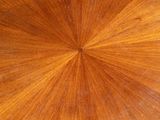 a close up of a wooden table with a circular design on the top