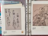 two pages of art work on display in a binder