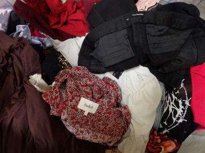 a woman sitting on a couch with a pile of clothes