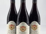 trois bouteilles de vin posées sur une table blanche