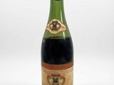 an old bottle of wine sitting on top of a white surface
