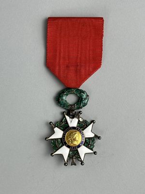 une image représentant une médaille ornée d'une étoile, suspendue à un ruban rouge