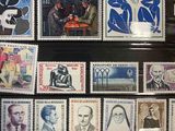 a lot of stamps that are on display in a glass case