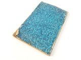 a small book with a blue cover sitting on a white surface