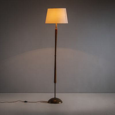 le lampadaire est posé sur une surface blanche et est muni d'un abat-jour blanc