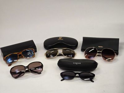 several pairs of sunglasses and a case on a white surface