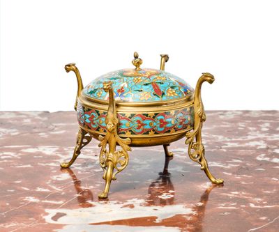 un bol doré et bleu posé sur un socle, lui-même posé sur un plateau en marbre