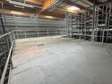 an empty warehouse filled with lots of shelves and metal racks