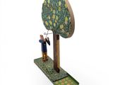wooden figurine of a man with a tree on a stand