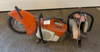 two chainsaws sitting next to each other in a garage
