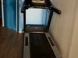 a treadmill in the corner of a room with a blue wall