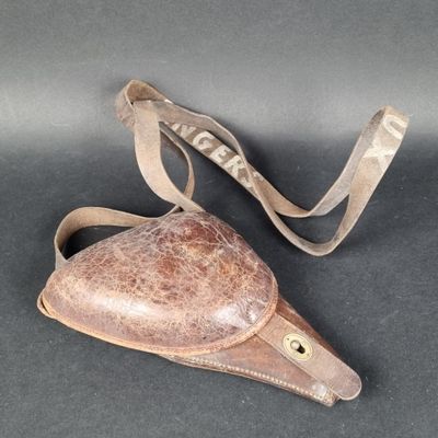 un vieux sac à main en cuir muni d'une bandoulière, posé sur une table