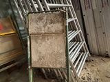 un tas de chaises et une chaise au milieu d'une pièce
