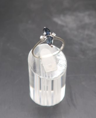 a ring with a blue stone sitting on top of a glass of water