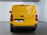 the back of a yellow van is parked in a large room
