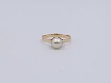 une bague en or avec une perle au centre