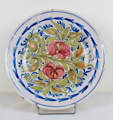 a blue and white plate with pink flowers on it
