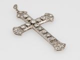 a close up of a diamond cross on a white surface