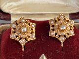 pair of pearl and gold earrings in a velvet case