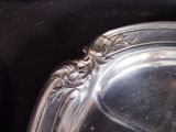 a silver plate with a handle on a black cloth