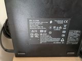 the back of a black laptop computer sitting on top of a wooden table