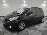 the black nissan versa is parked on a checkered tile floor