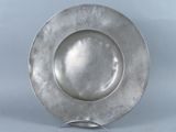 a silver plate on a metal stand on a blue background