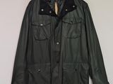 une veste en cuir noir accrochée au mur à côté d'un cintre en bois