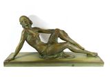 bronze sculpture of a woman laying on a marble base