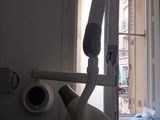 un fauteuil de dentiste devant une fenêtre, dans une pièce