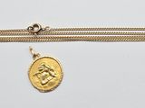 un collier en or avec une pièce de monnaie sur une chaîne