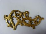 a gold brooch on a white surface