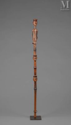 une image représentant une sculpture en bois d'un homme sur un poteau
