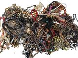 a pile of assorted jewelry on a white surface