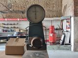 a large clock sitting on top of a table in a warehouse
